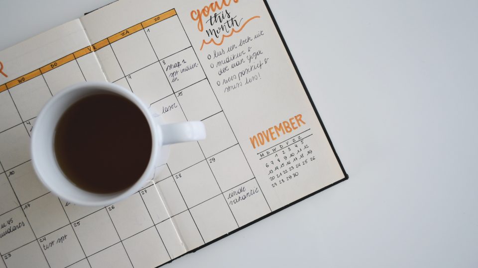 Image of a coffee cup on top of a diary depicting my goals for 2020.